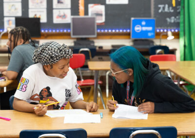 Two students in a classroom working on an assignment.