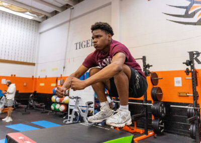 A person in a gym jumping onto a mat.