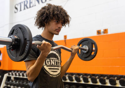 A person in gym lifting weights.