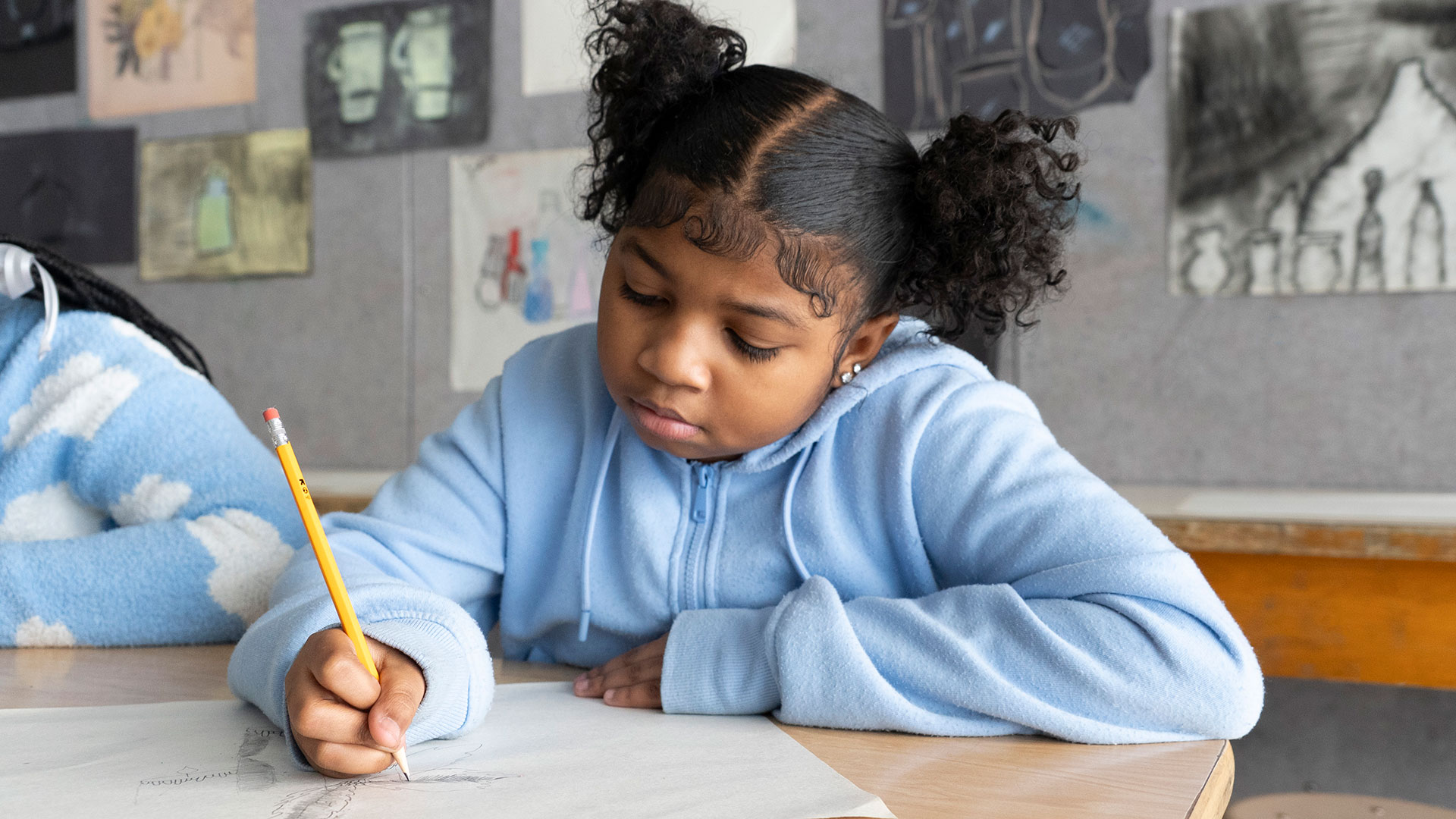 A girl in a classroom drawing.