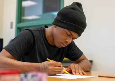 A student at a table drawing.