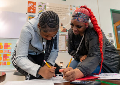 Two girls work on an assignment together.