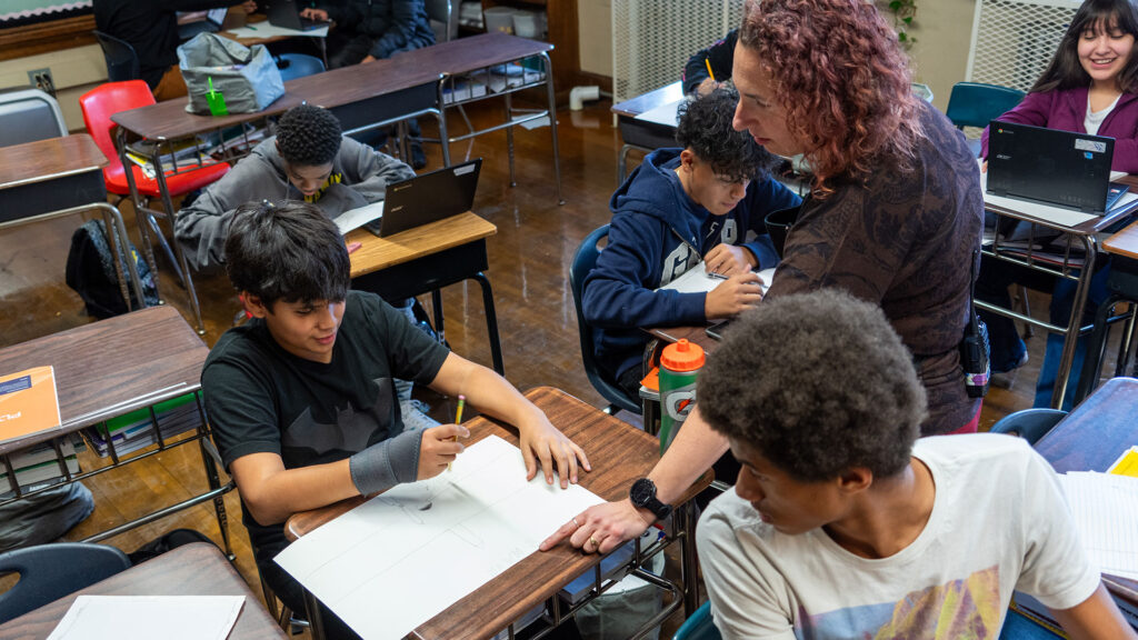 A teacher helps her students.