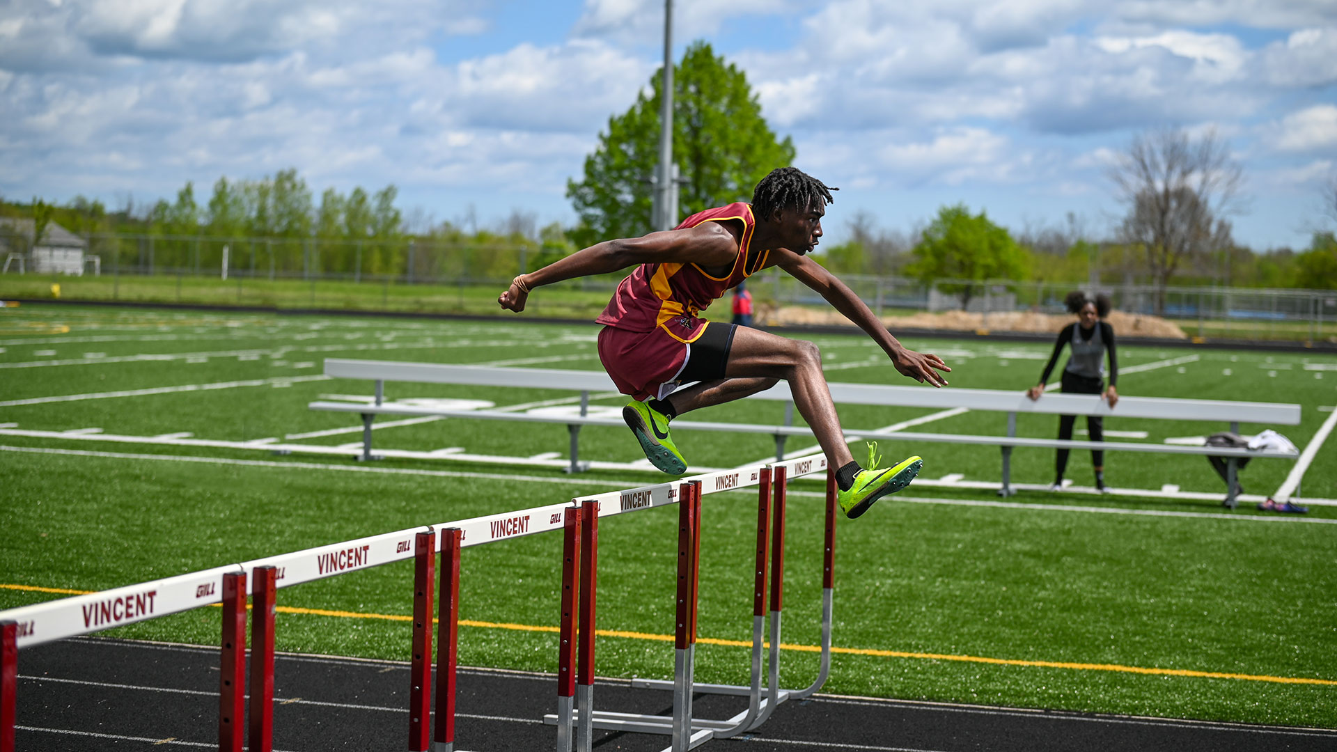 A runner on a check jumping over a hurdle.