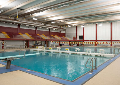 An empty swimming pool with diving board.