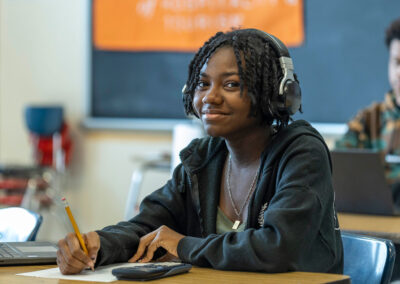 A student wearing headphones smiling.