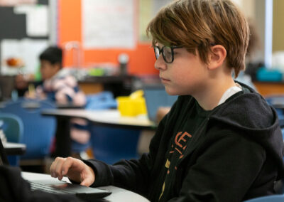 A child in a classroom using a computer.