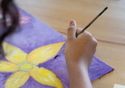 Close-up of a hand painting a flower.