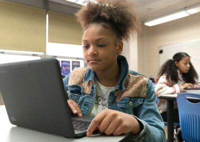 Children at tables using computers.