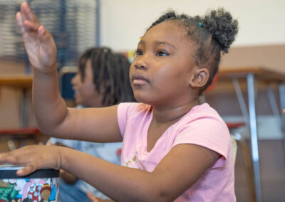 A young girl concentrates as she drums.