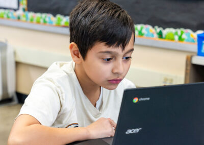 A student in a classroom using a computer.