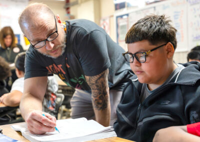 A teacher helps a student.