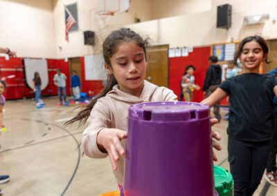 Children in a gymnasium stacking buckets.