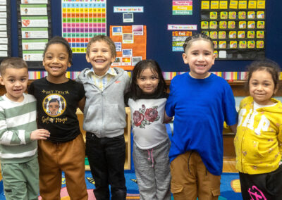 Young students with their arms around one another.