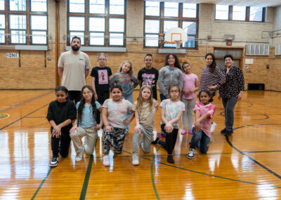 A group of girls and a few teachers in a gymnasium.